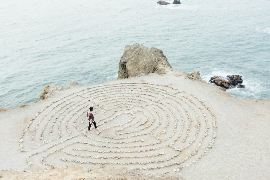 Person walking a stone labyrinth on a California coastal bluff